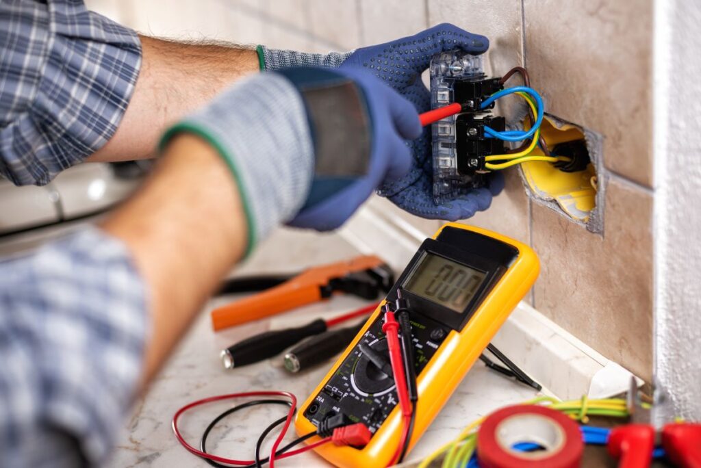 Electrician at work with safety equipment on a residential electrical system
