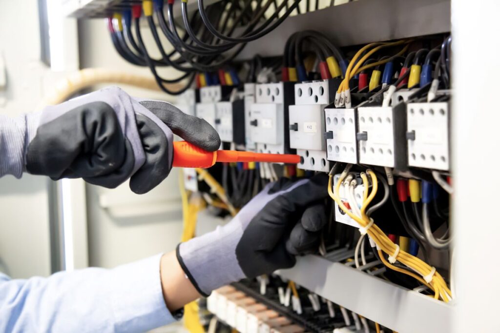 Electricians work to connect electric wires in the system
