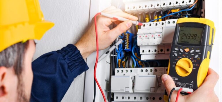 Electrician installing electric cable wires of fuse switch box.