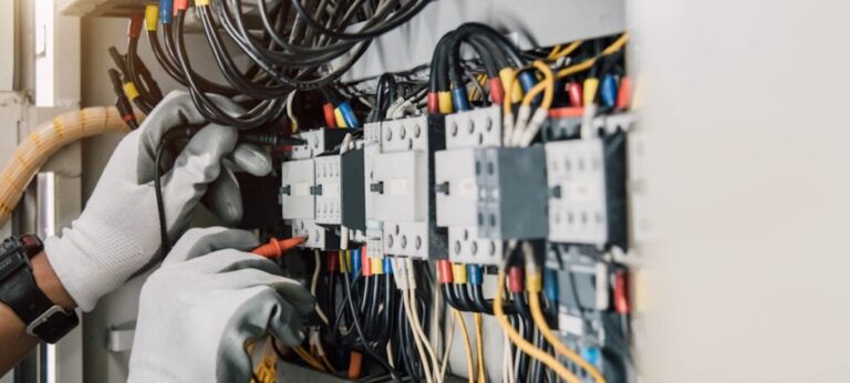 Electrician engineer tests electrical installations and wires on relay protection system.