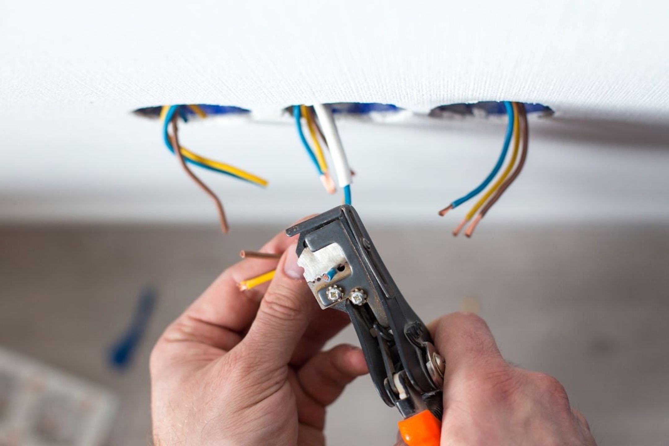 Electrician-stripping-insulation-from-wire-for-installation-an-electrical-outlet