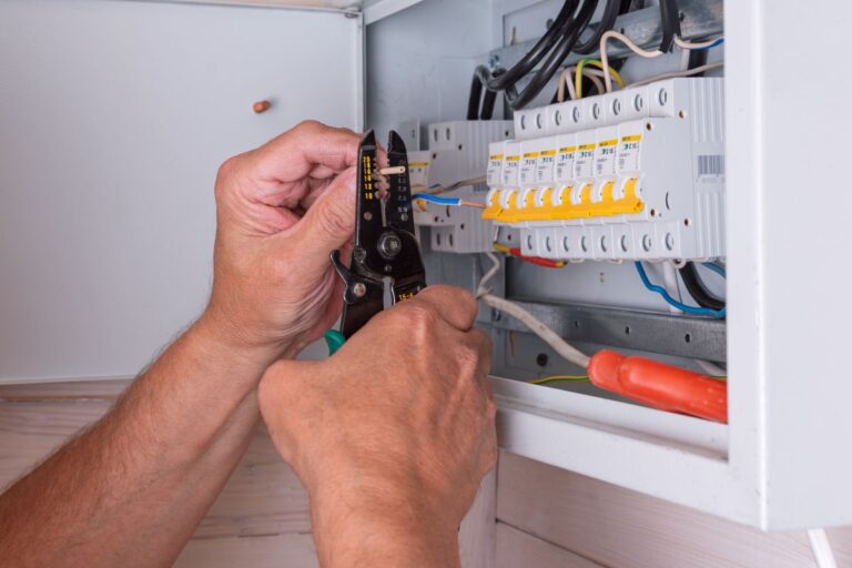 hands working on modern electric panel fixing wires