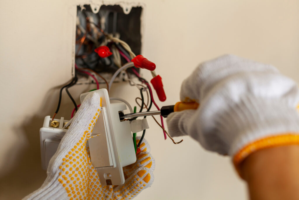 An electrician is replacing a wall switch. 