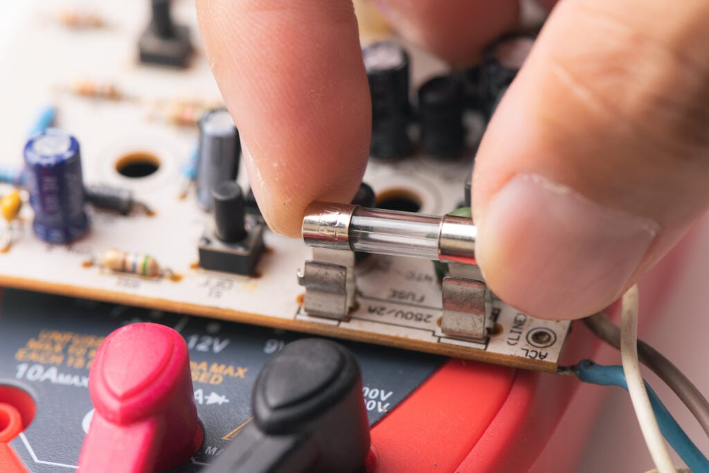 what does a blown fuse look like hand placing fuse in electric board