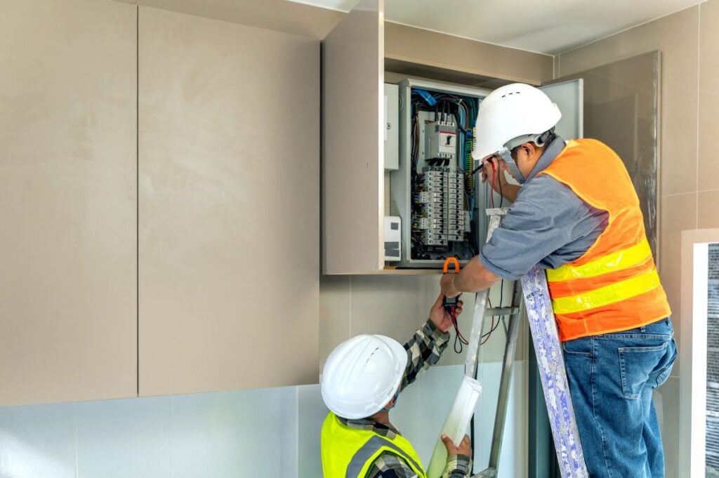 smart electrical panel worker on top of ladder installing new breakers