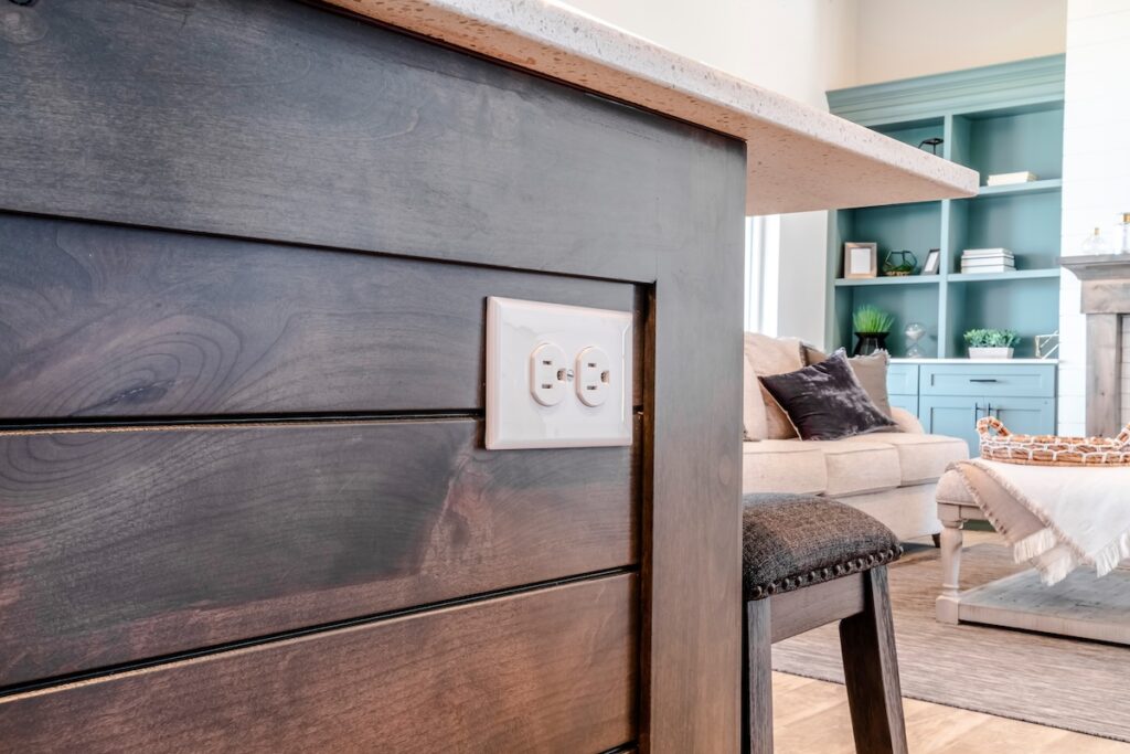 Electrical outlet with three slot receptacles installed on the kitchen island. 