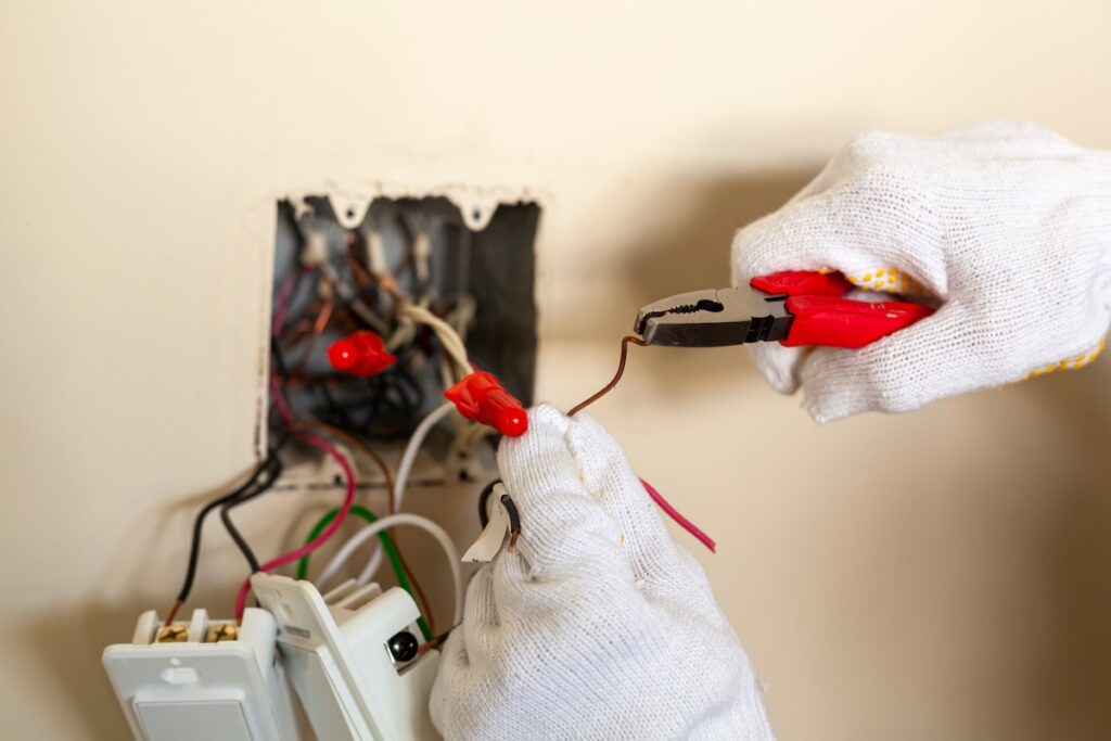 An electrician is replacing a wall switch. 