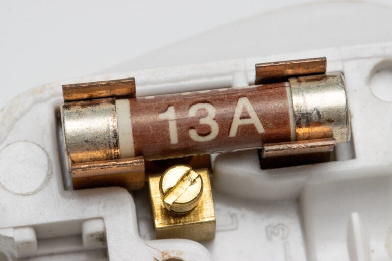 what does a fuse do 13 ampere ceramic fuse on its holder isolated on white background.